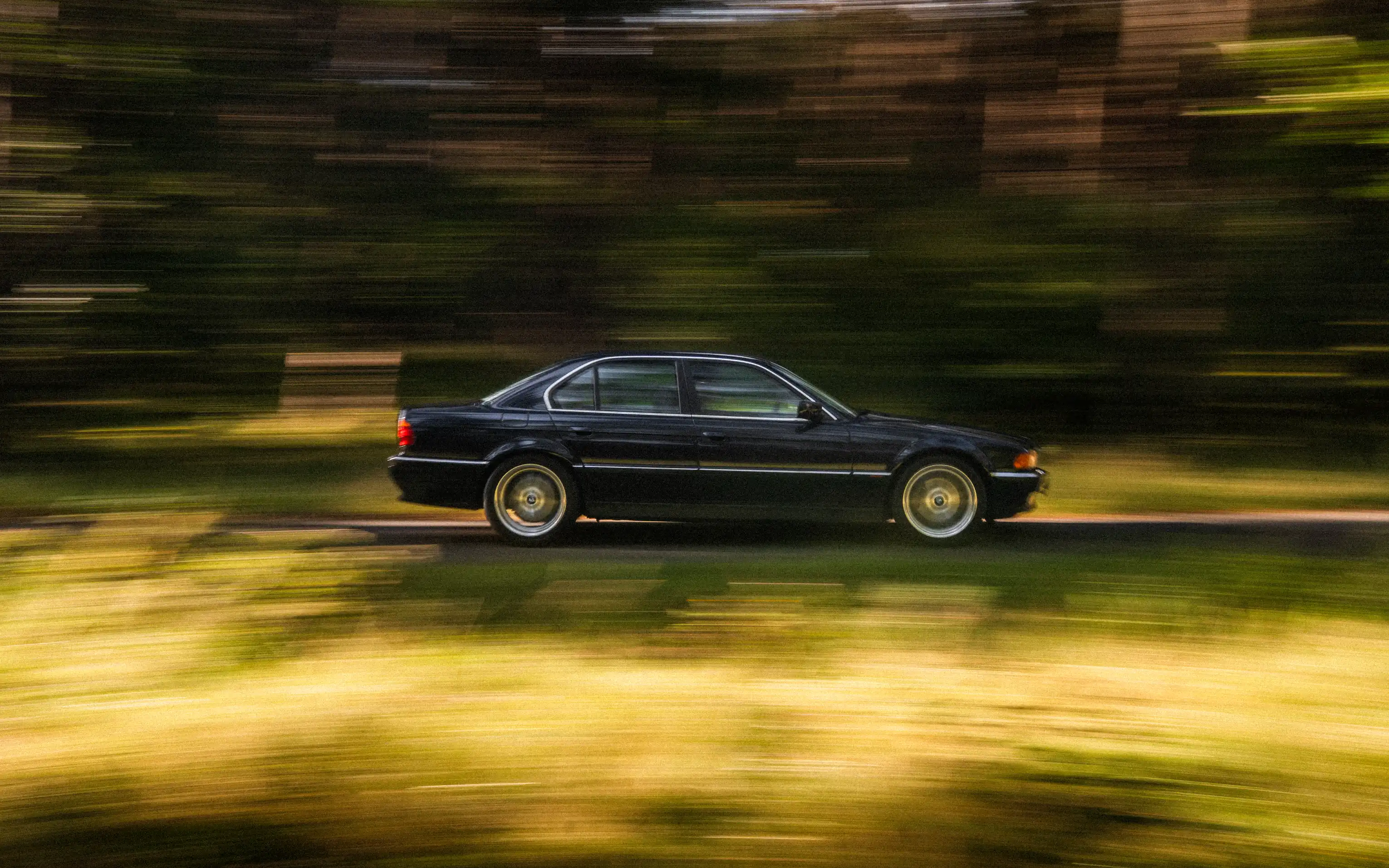 BMW E38 w ruchu na leśnej drodze